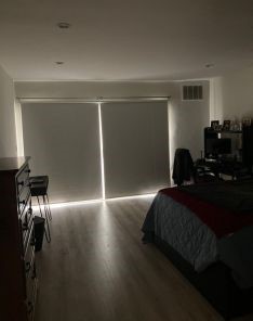 Custom blackout roller shades installed, completely blocking light on bedroom balcony doors in Mill Valley home