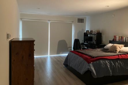 Custom blackout roller shades installed, completely blocking light on bedroom balcony doors in Mill Valley home