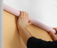 A male installing blackout roller shades